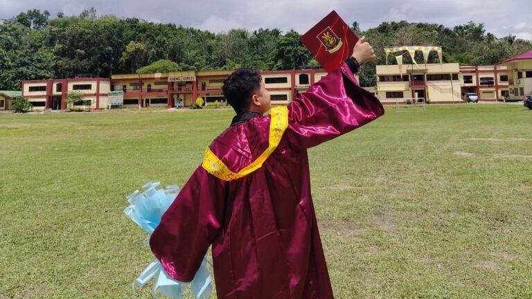 A Proud Graduate. Charlie Dillera proudly holds up his MSU Graduation Certificate in his toga, marking his achievement as a graduate of Environmental Science and a proud TVIRD scholar.
